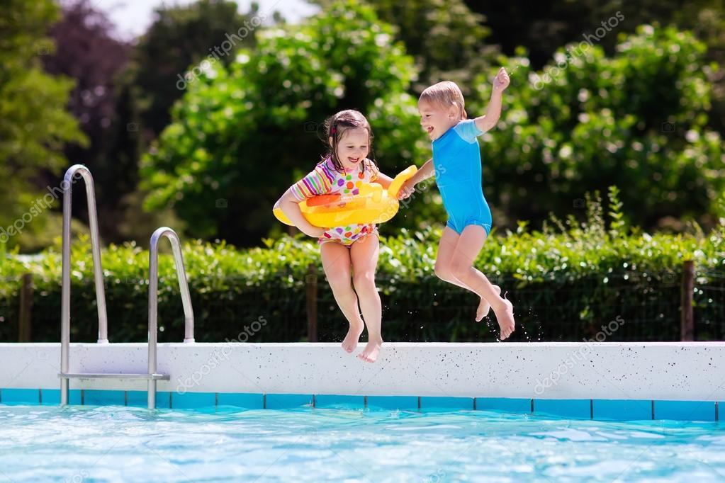 Kids jumping into swimming pool — Stock Photo © FamVeldman
