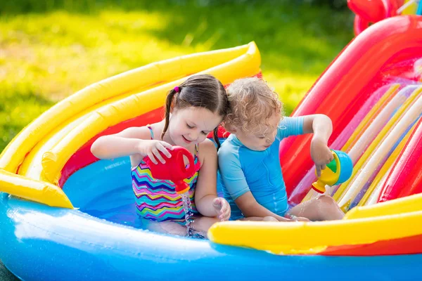 Kids playing in inflatable swimming pool — Stock Photo, Image