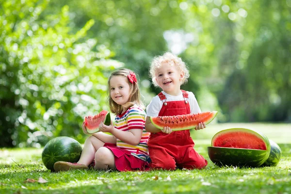 Crianças comendo melancia no jardim — Fotografia de Stock