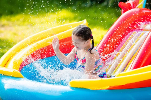 Little girl in garden swimming pool — Stock Photo, Image