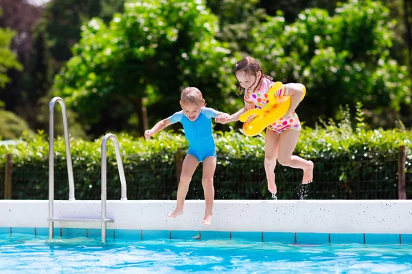 Kids jumping into swimming pool — Stock Photo, Image