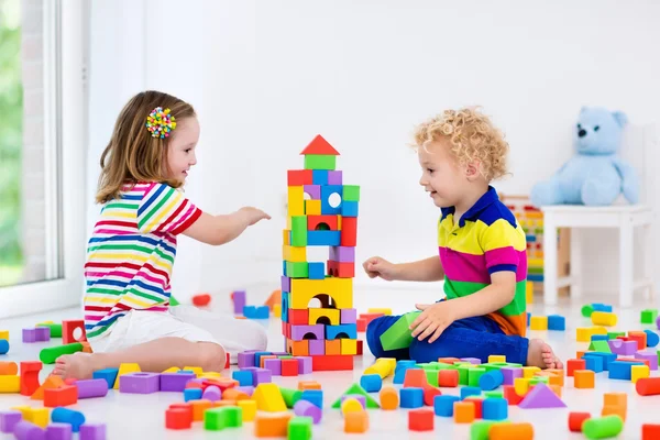 Crianças brincando com blocos de brinquedos coloridos — Fotografia de Stock
