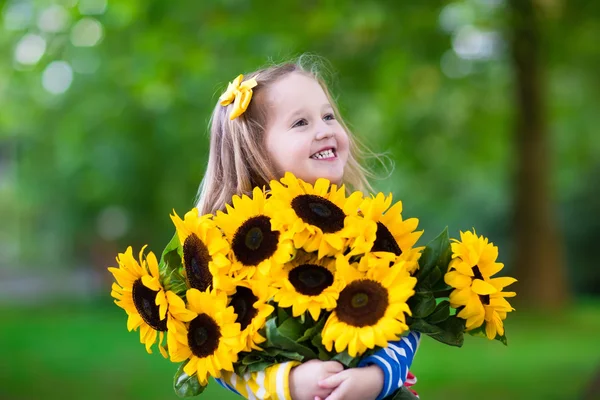 Malá holčička se slunečnicemi — Stock fotografie