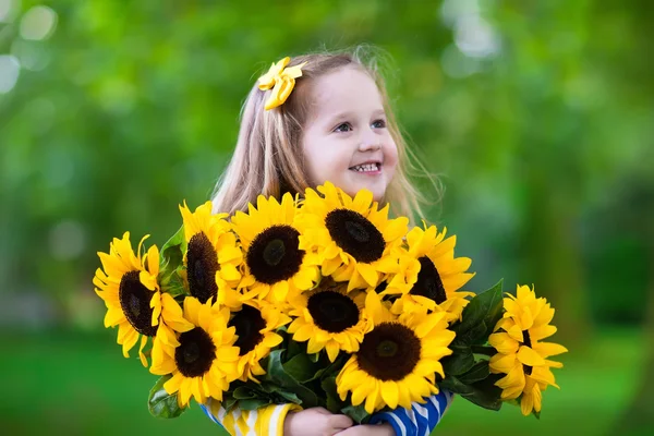 Kleines Mädchen mit Sonnenblumen — Stockfoto