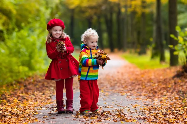 Niños jugando en el parque de otoño —  Fotos de Stock