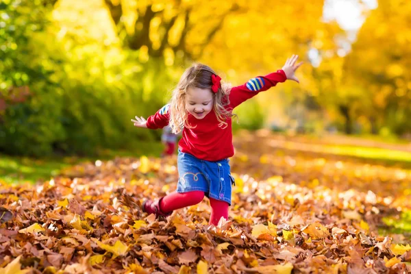 Menina brincando no parque de outono — Fotografia de Stock