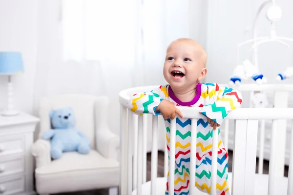 Liten pojke stående i sängen — Stockfoto