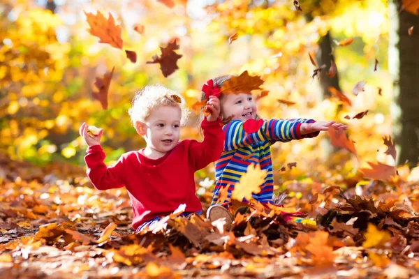 Niños jugando en el parque de otoño — Foto de Stock