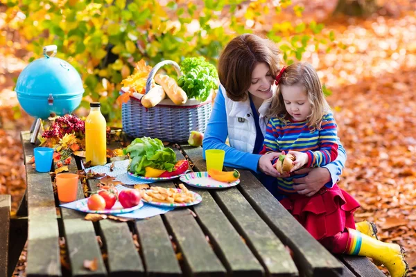 Мать и дочь накрывают стол для пикника осенью — стоковое фото
