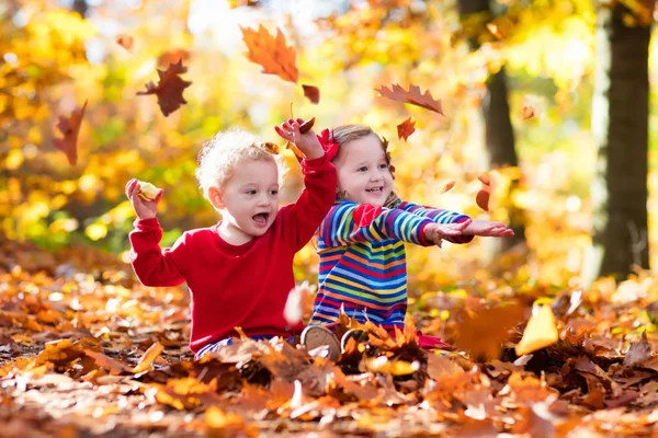 Děti hrají v podzimním parku — Stock fotografie