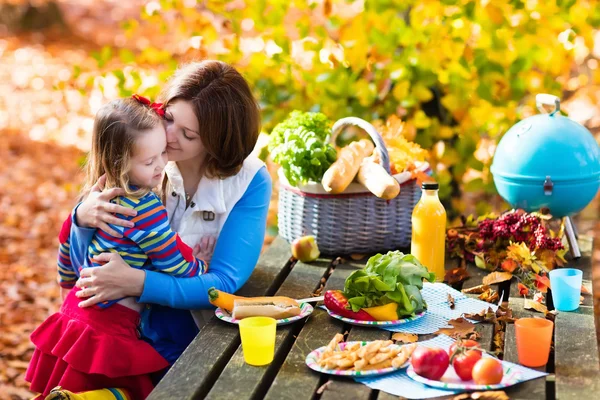 Mother and daughter set table for picnic in autumn — Stock Photo, Image