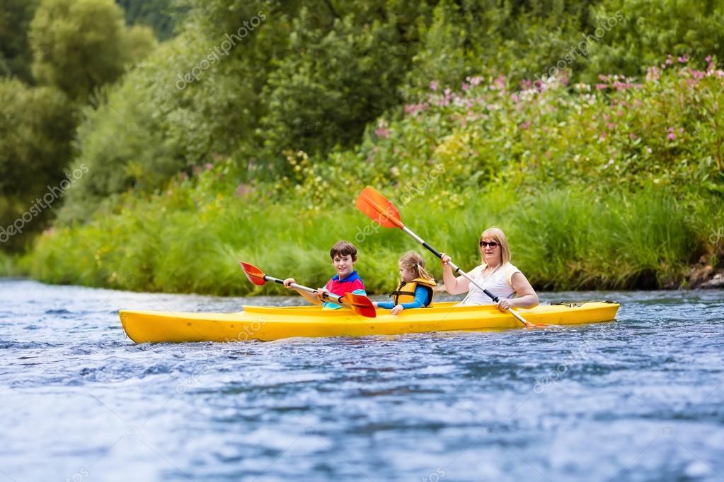 Familia disfrutando del paseo en kayak por un río fotografía de stock