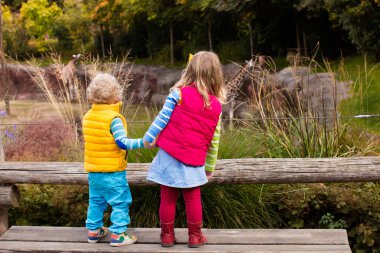 Hayvanat bahçesi hayvanları izlerken çocuklar