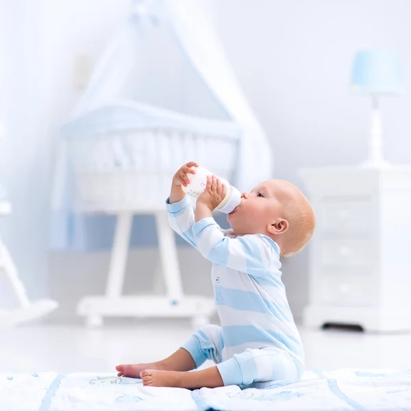 Baby pojke konsumtionsmjölk i soliga plantskola — Stockfoto