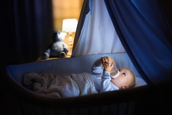 Bebé niño beber leche en la cama — Foto de Stock