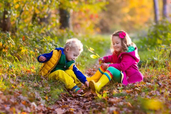 Niños jugando en el parque de otoño — Foto de Stock