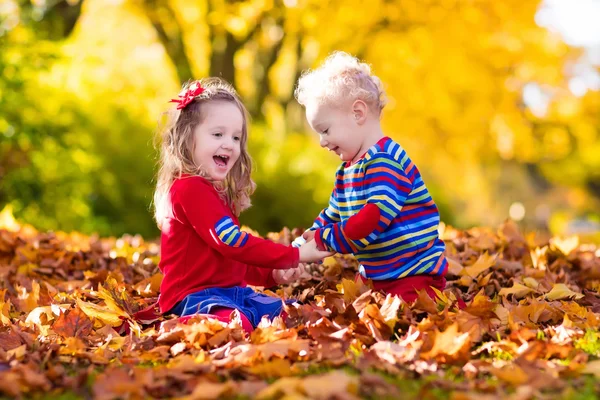 Niños jugando en el parque de otoño — Foto de Stock