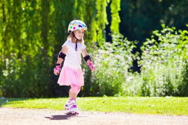 Küçük kız bir parkta paten ayakkabı ile