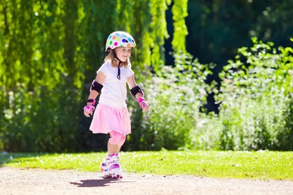 Маленькая девочка в роликовых туфлях в парке — стоковое фото