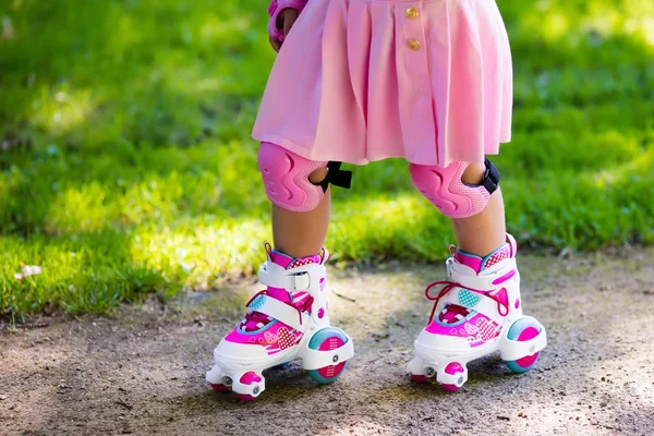 Kleines Mädchen mit Rollschuhen im Park — Stockfoto