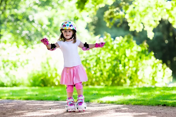 Petite fille avec des chaussures de patin à roulettes dans un parc — Photo