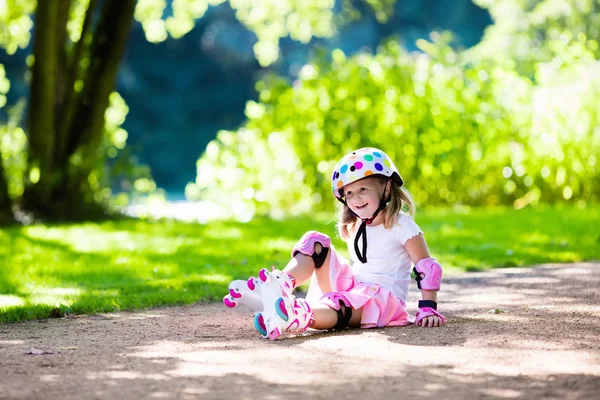 Gadis kecil dengan sepatu roda di taman. — Stok Foto