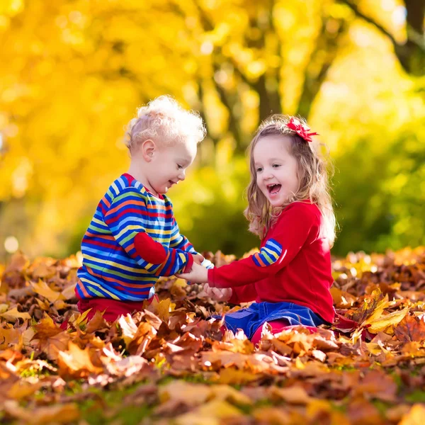 Niños jugando en el parque de otoño —  Fotos de Stock