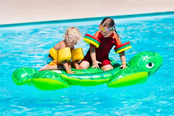 Děti v bazénu s nafukovací hračky — Stock fotografie