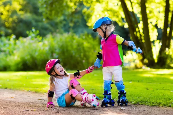 Детское катание на роликах в летнем парке — стоковое фото
