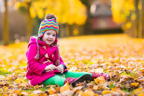 Klein meisje spelen in herfst park — Stockfoto