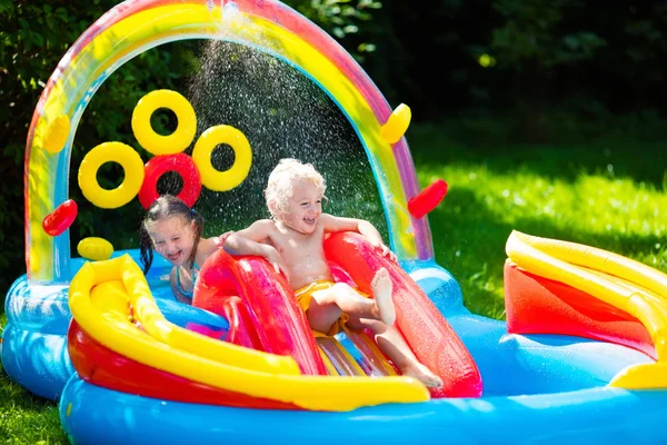 Barn som leker i uppblåsbar pool — Stockfoto
