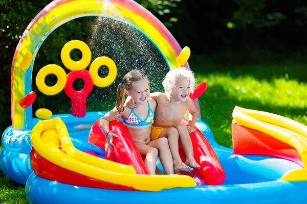 Crianças brincando na piscina inflável — Fotografia de Stock