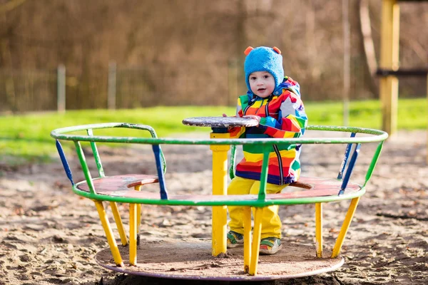 Kleine jongen op speelplaats in de herfst — Stockfoto