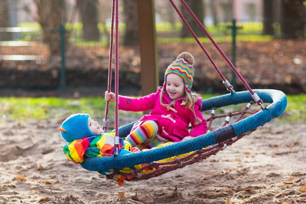 Kids on playground swing — Stock Photo, Image