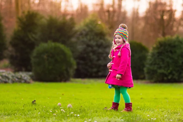 Маленькая девочка играет в осеннем парке — стоковое фото