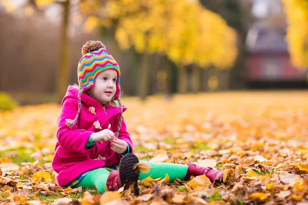 Kleines Mädchen spielt im Herbstpark — Stockfoto