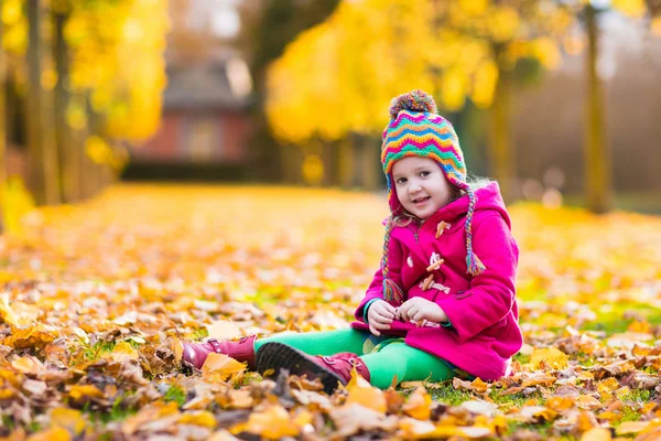 Niña jugando en el parque de otoño — Foto de Stock