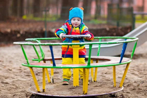Kleine jongen op speelplaats in de herfst — Stockfoto