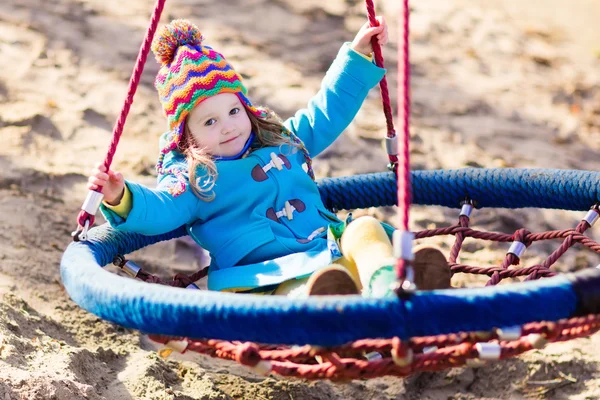 Child on playground swing — Stock Photo, Image