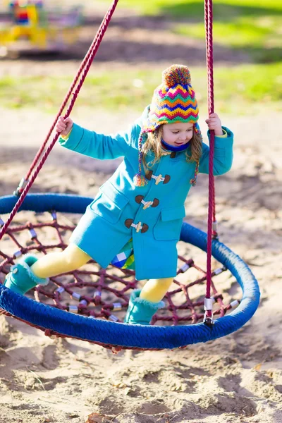 Child on playground swing — Stock Photo, Image