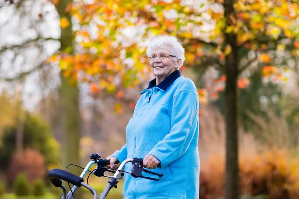 Señora mayor con un andador en el parque de otoño — Foto de Stock