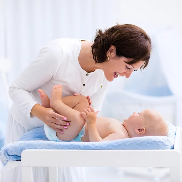 Moeder en baby over het wijzigen van de tabel — Stockfoto