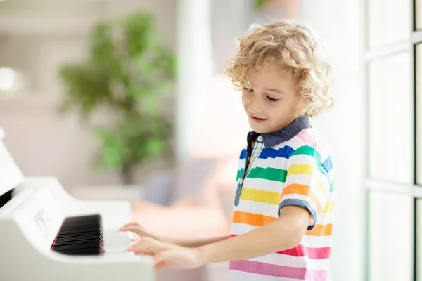 孩子弹钢琴 孩子们弹奏音乐 儿童的经典教育 艺术课 小男孩在白色数字键盘 年轻学生的乐器 学校或家里的音乐课 — 图库照片