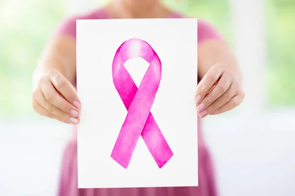 Woman holding pink ribbon poster. Breast cancer awareness. Think pink month. Health care poster. Support and sympathy sign.