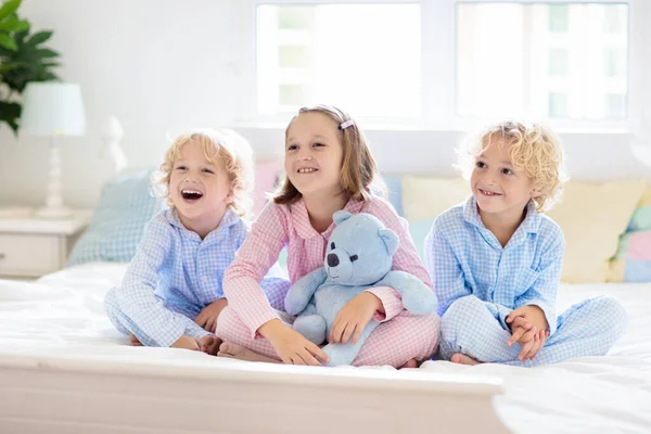 Çocuklar Yatakta Oynar Çocuklar Beyaz Güneşli Yatak Odasında Kardeş Pijamalarıyla — Stok fotoğraf