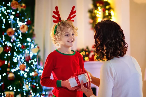 Family visiting grandmother on Christmas day. Kids with gifts at home front door. Xmas celebration with grandparents. Child with presents at house entrance. Winter holiday celebration. Surprise visit.