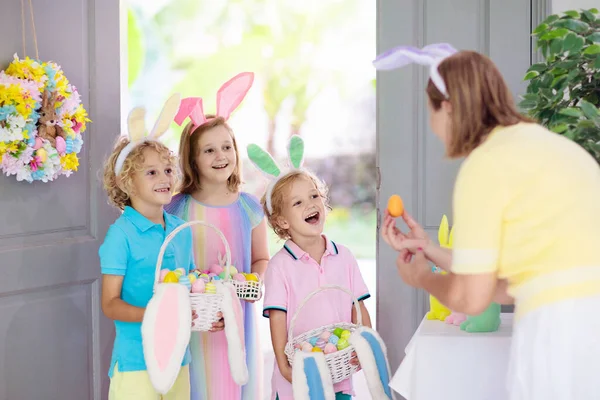 부활절 사냥하는 초콜릿 달걀로 바구니를 있는아이 부활절 기념행사가 현관문에 어린이들은 — 스톡 사진