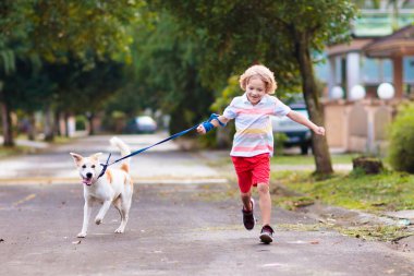 Çocuk gezdiren köpek. Çocuk köpek yavrusuyla oynuyor. Küçük çocuk evcil hayvanıyla koşuyor. Mahallenin varoşlarında çocuklar oynuyor. Hayvan arkadaşlar. Arkadaşlık ve aşk.