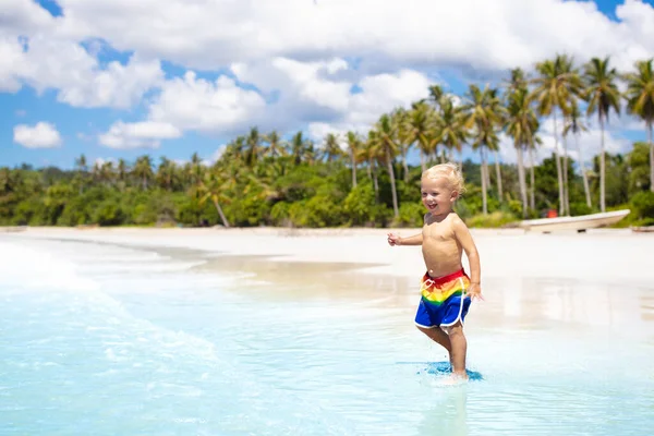 ヤシの木と熱帯のビーチで遊んでいる子供 海の岸にいる小さな男の子 家族の夏休み 子供たちは水と砂のおもちゃで遊ぶ 海と島の楽しみ アジアの若い子供たちと一緒に旅行 — ストック写真