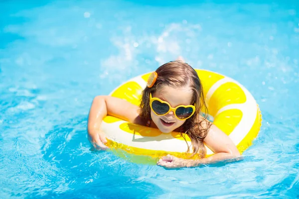 膨脹可能な黄色のレモンリングのプールで子供 オレンジ色のフロートで泳ぐことを学ぶ少女 赤ちゃんや幼児のための水のおもちゃ 子供のための健康的な屋外スポーツ活動 子供のビーチの楽しみ — ストック写真